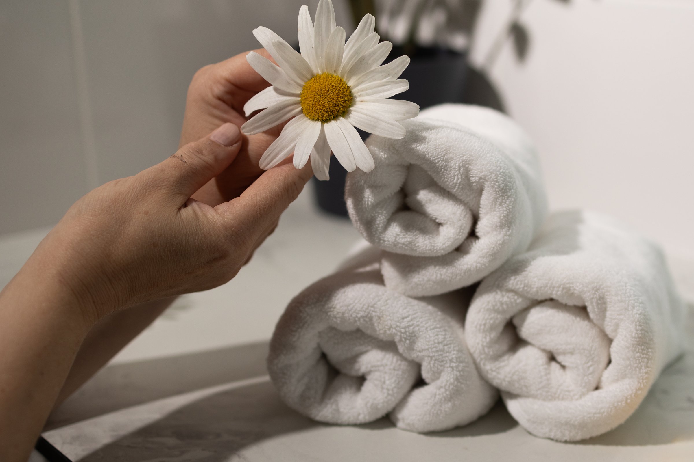 Soft white towels arranged neatly creating a calming spa atmosphere