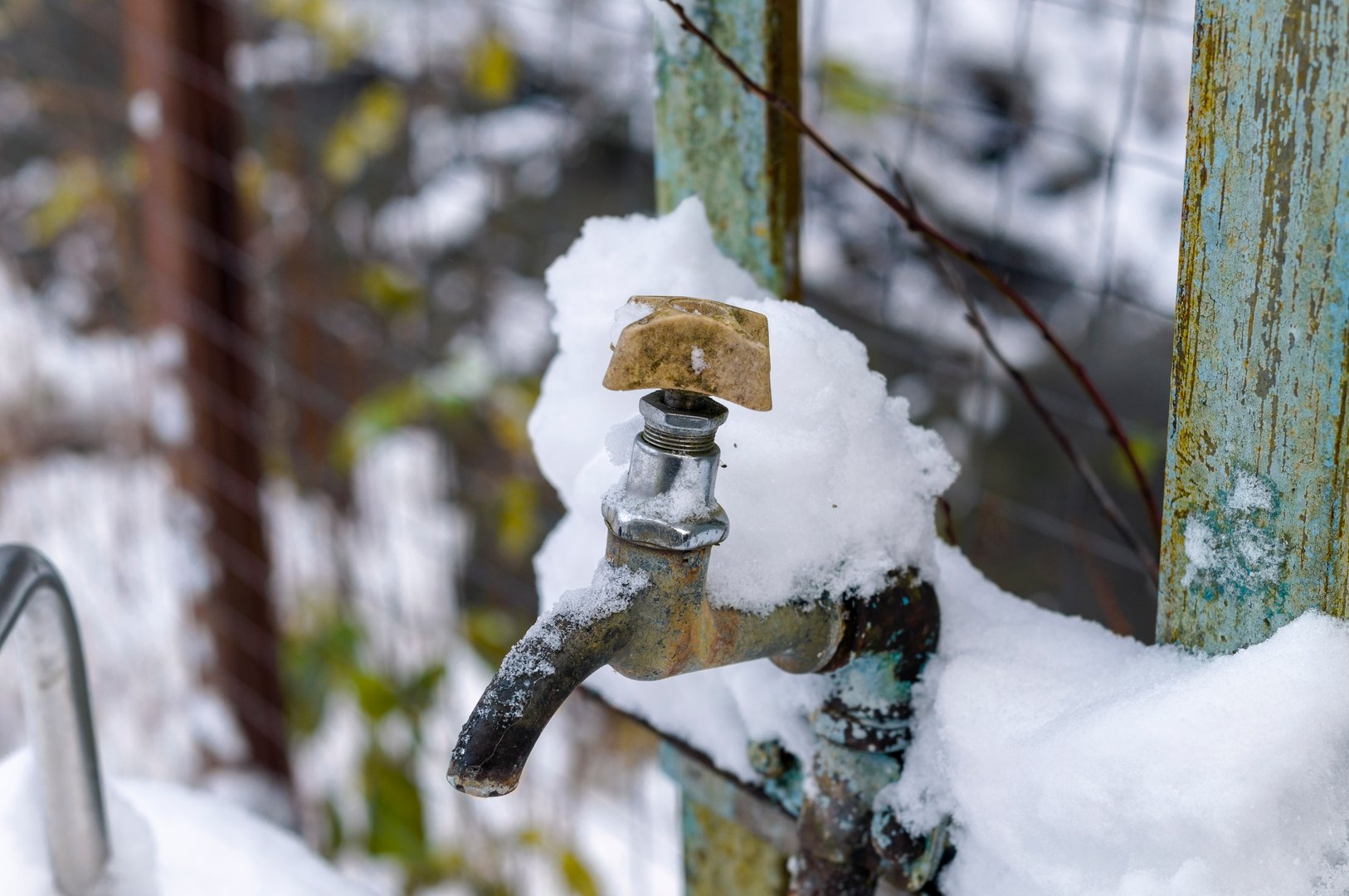 old metal tap covered with ice and snow, winter scene
