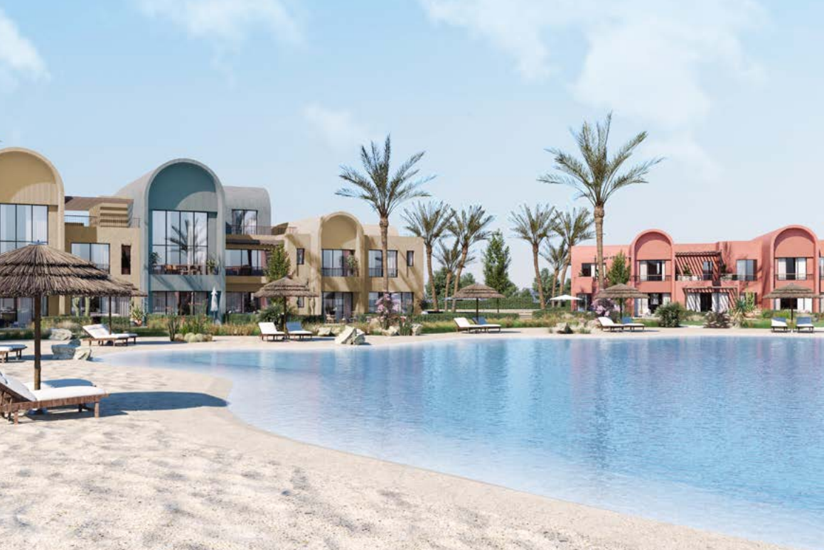 Beachfront resort with modern villas, palm trees, and a swimming pool. Lounge chairs are positioned on the sandy beach.