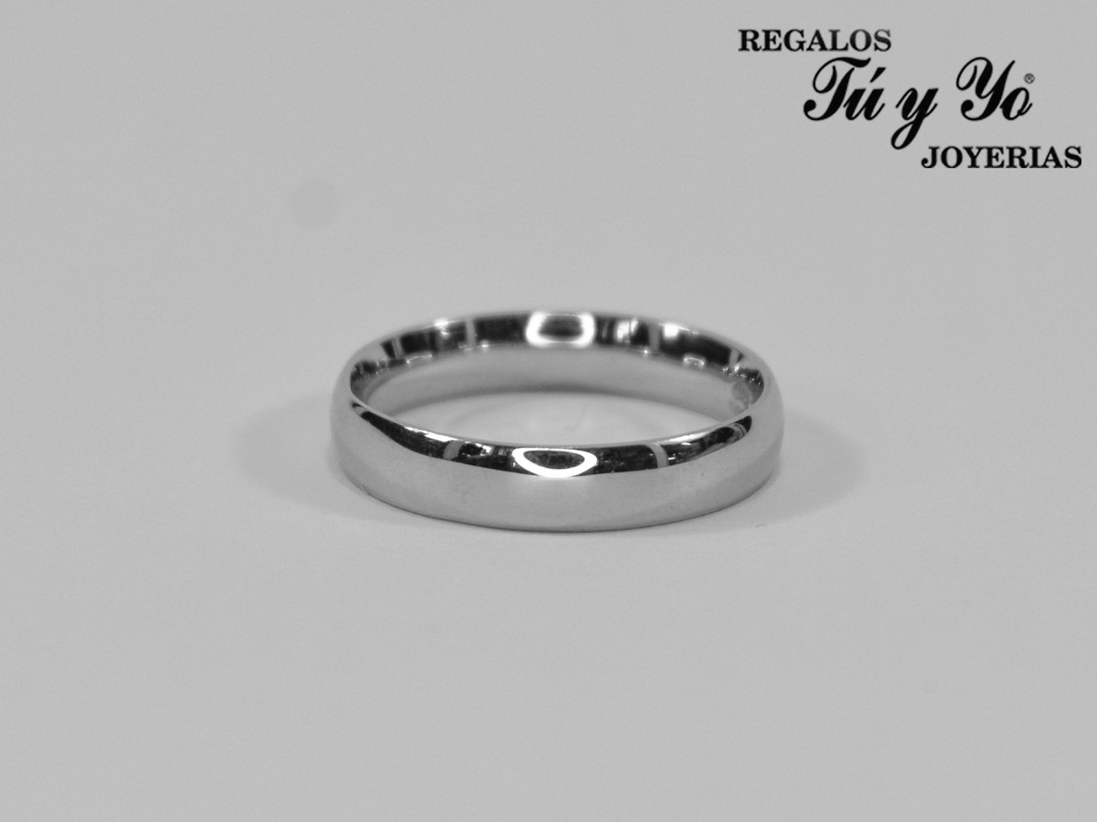 Silver wedding band with a smooth finish on a light grey background, featuring the logo 'Regalos Tú y Yo Joyerias' in the corner.