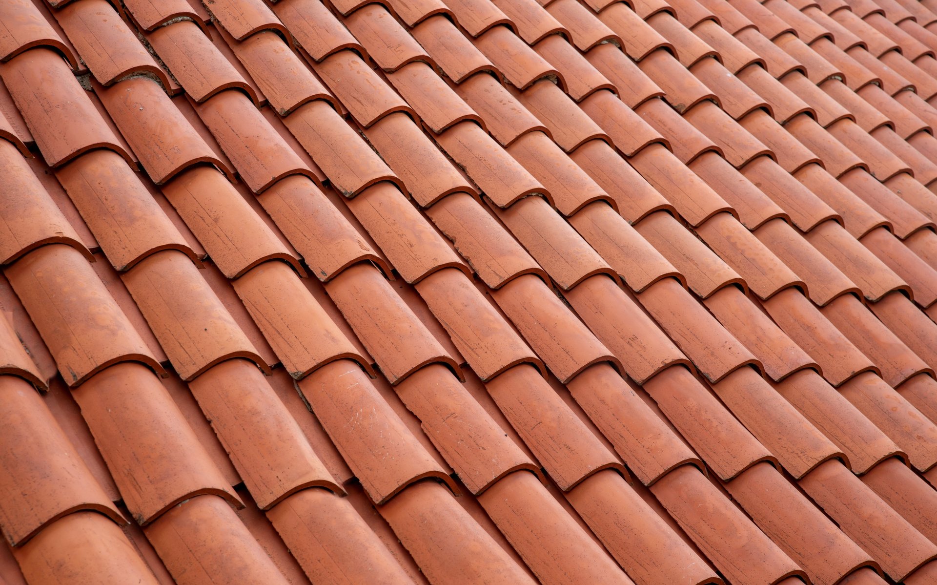 Terracotta clay roof tiles with curved profile in overlapping rows