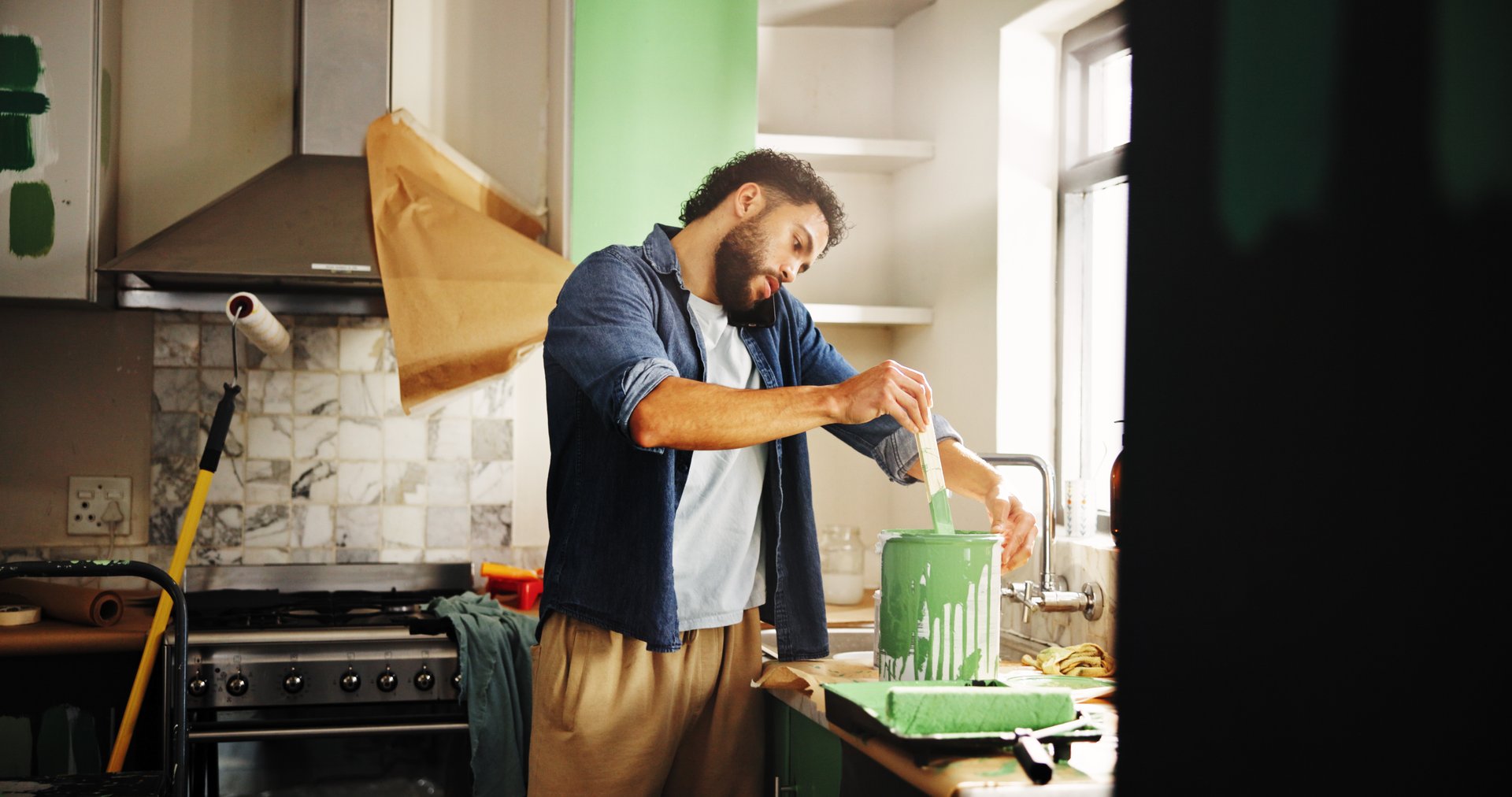 Renovation, paint and man with phone call in home for color ideas, makeover update or decor advice. Kitchen remodeling, homeowner and contact supplier for diy maintenance supplies or creative process