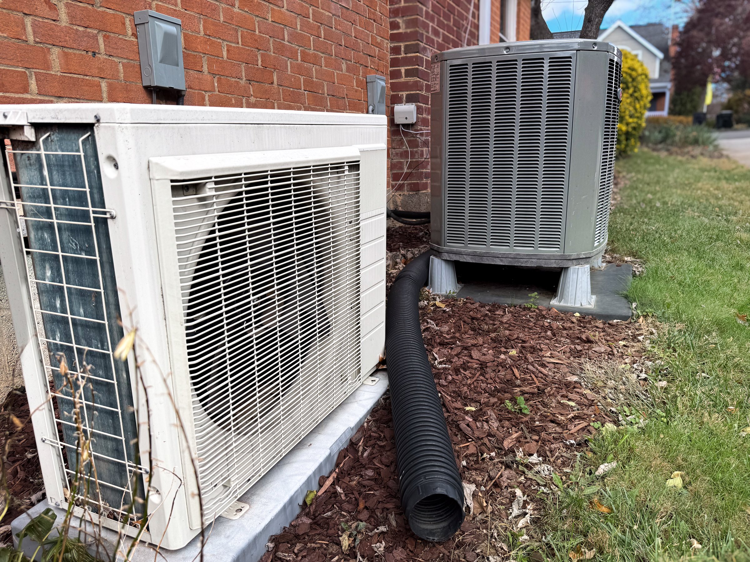 Outdoor dual zone heat pumps next to house
