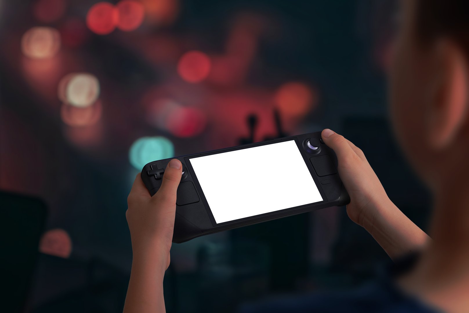 Boy holding a handheld gaming console playing a game in low light evening setting, perfect for mockup presentations showcasing immersive gaming experiences and design