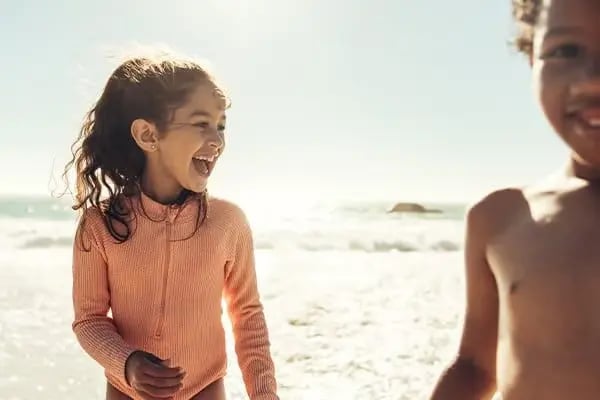 Happy young girl with healthy teeth after children dentistry treatment with gentle pediatric dental care