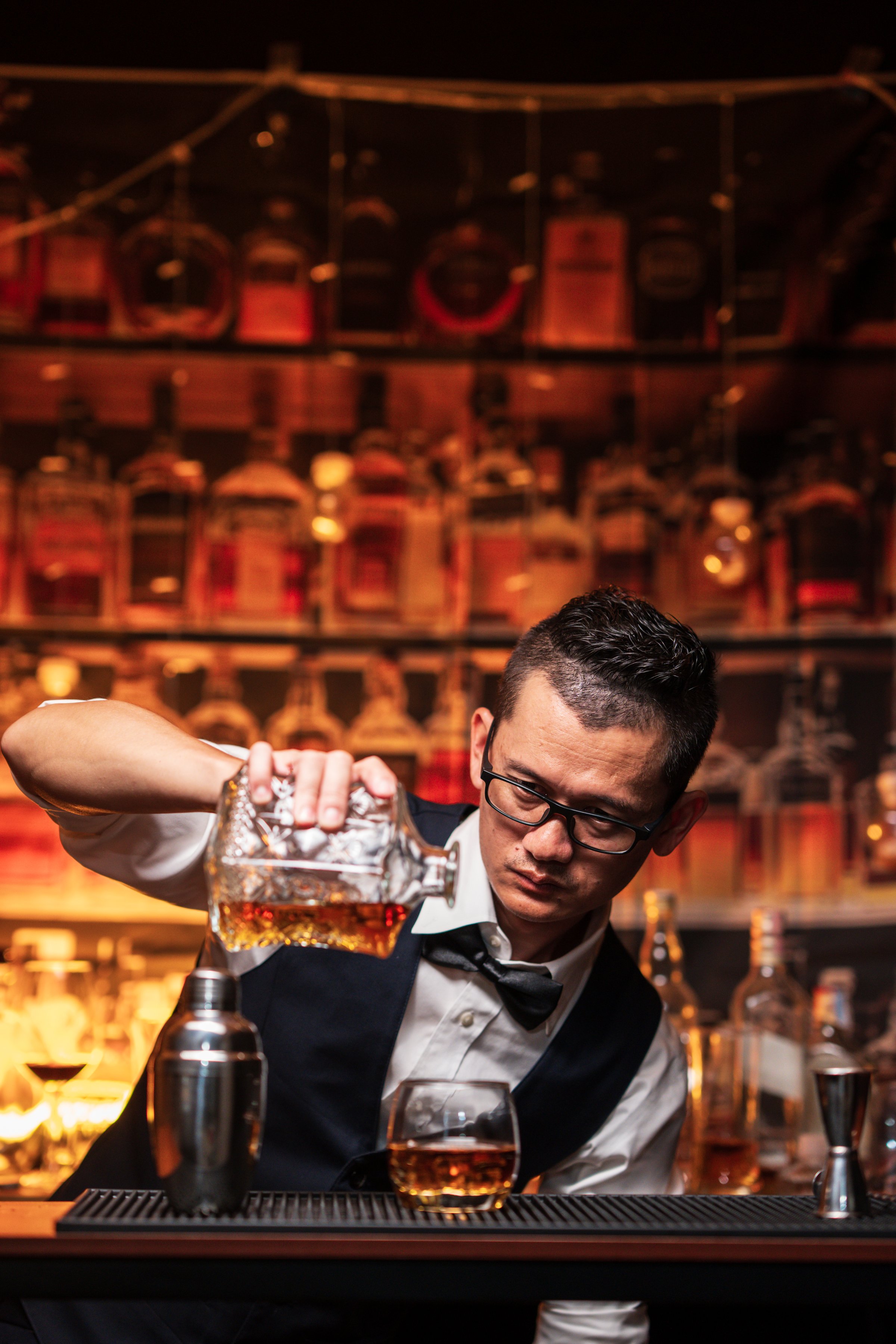 Bartender is pouring whiskey into a customer's glass