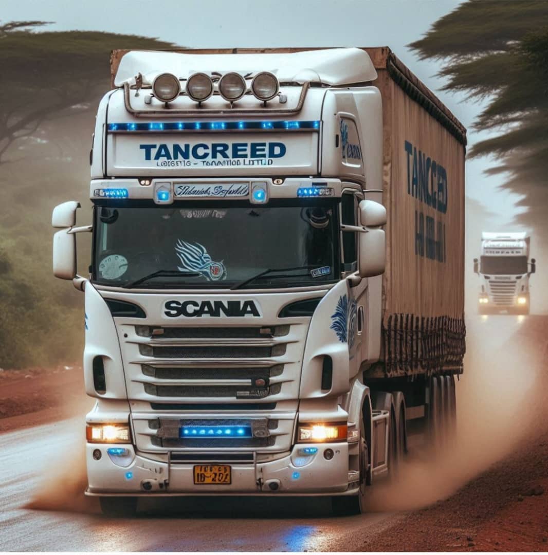 A large Scania truck with "TANCREED" branding driving on a dusty road, followed by another truck in the distance.