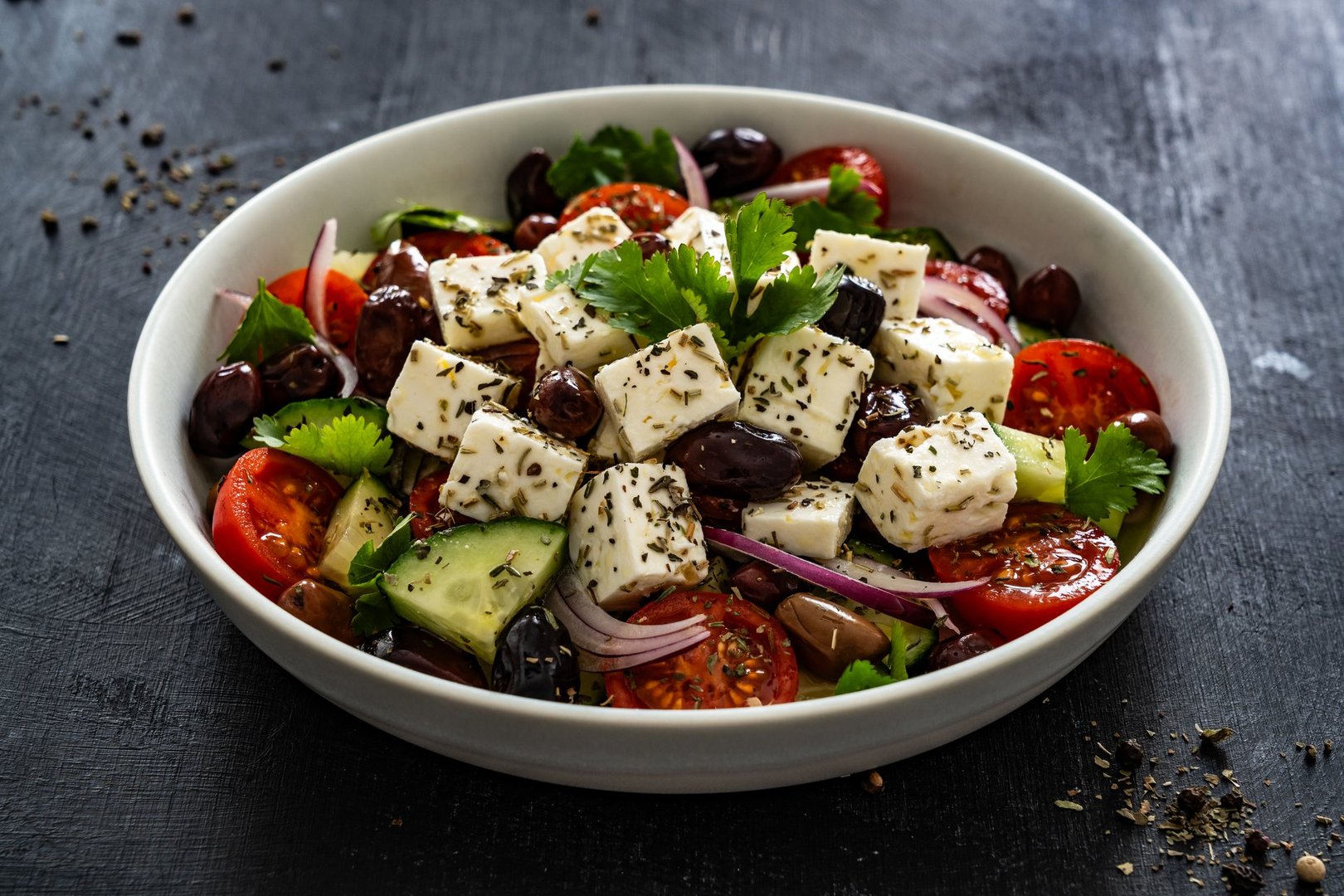 Greek style salad - fresh vegetables with feta cheese on wooden table