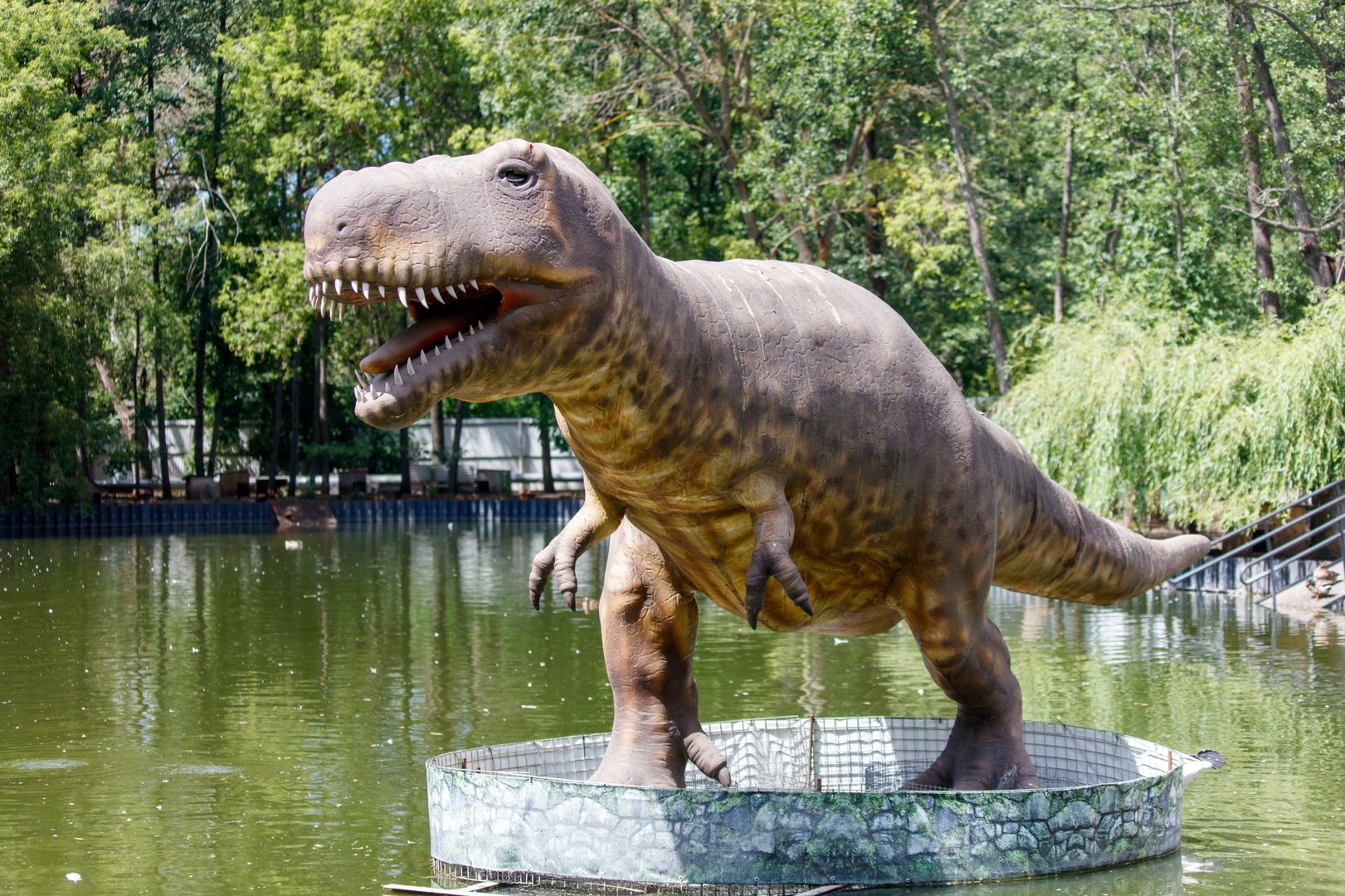 Dinosaur sculpture on the lake in the park.