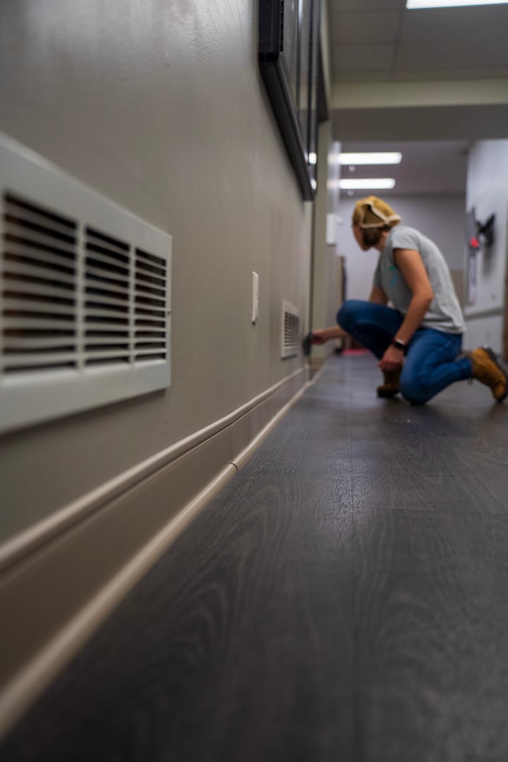 Professional cleaner in action wearing green uniform and yellow gloves