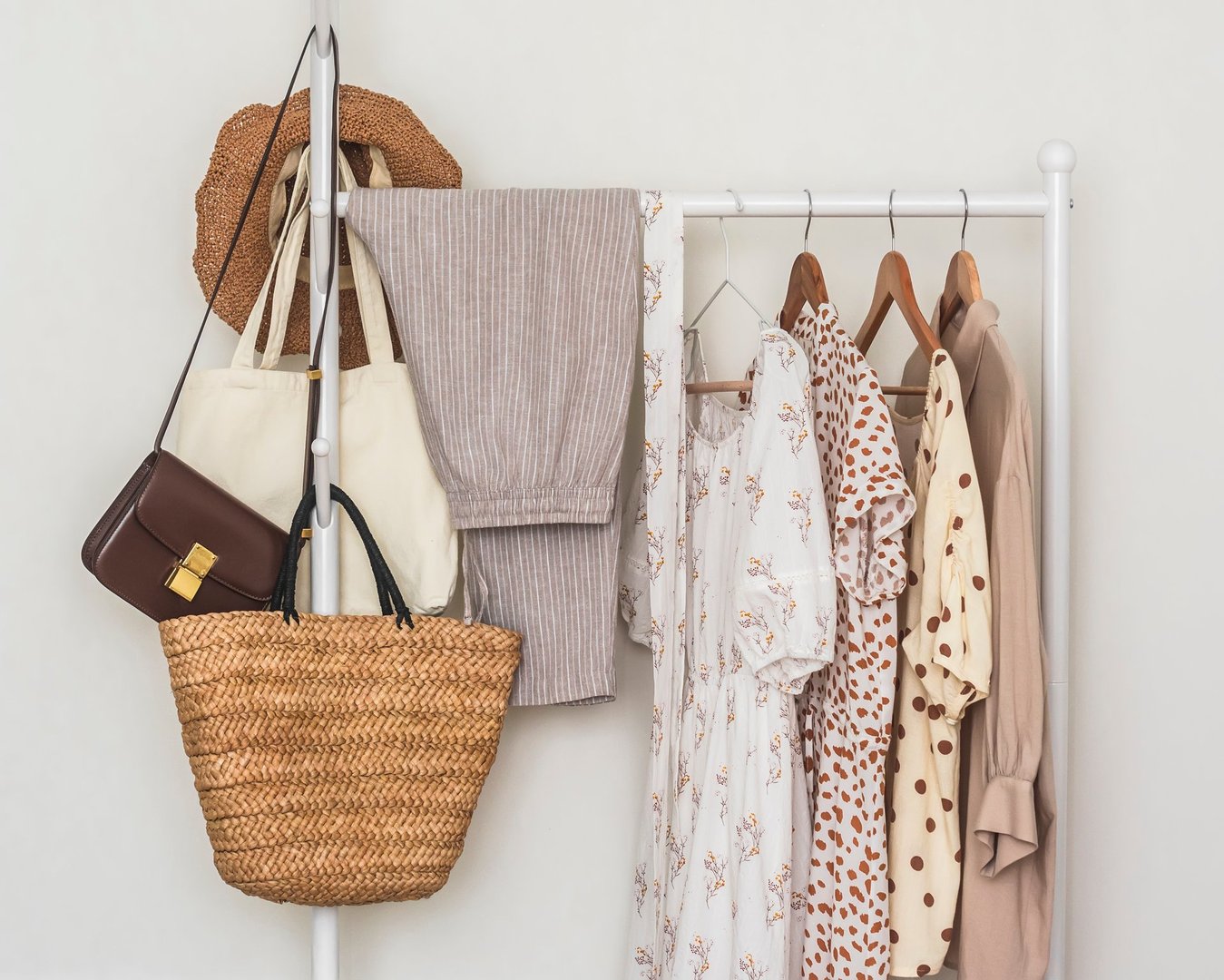 Spring summer women's clothing for walking traveling on a hanger. Natural fabric blouses, dresses, trousers and bags