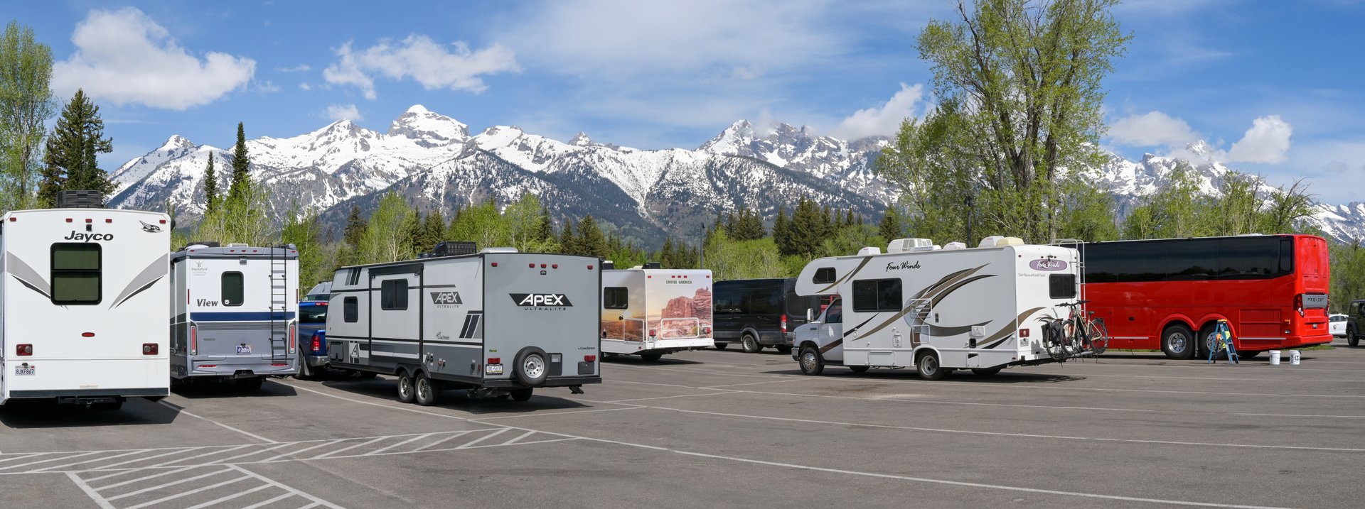 Jackson, Wyoming, USA - 28 may 2025: Camper vans and camping trailers parked in front of snow-capped mountains in the Grand Teton National Park