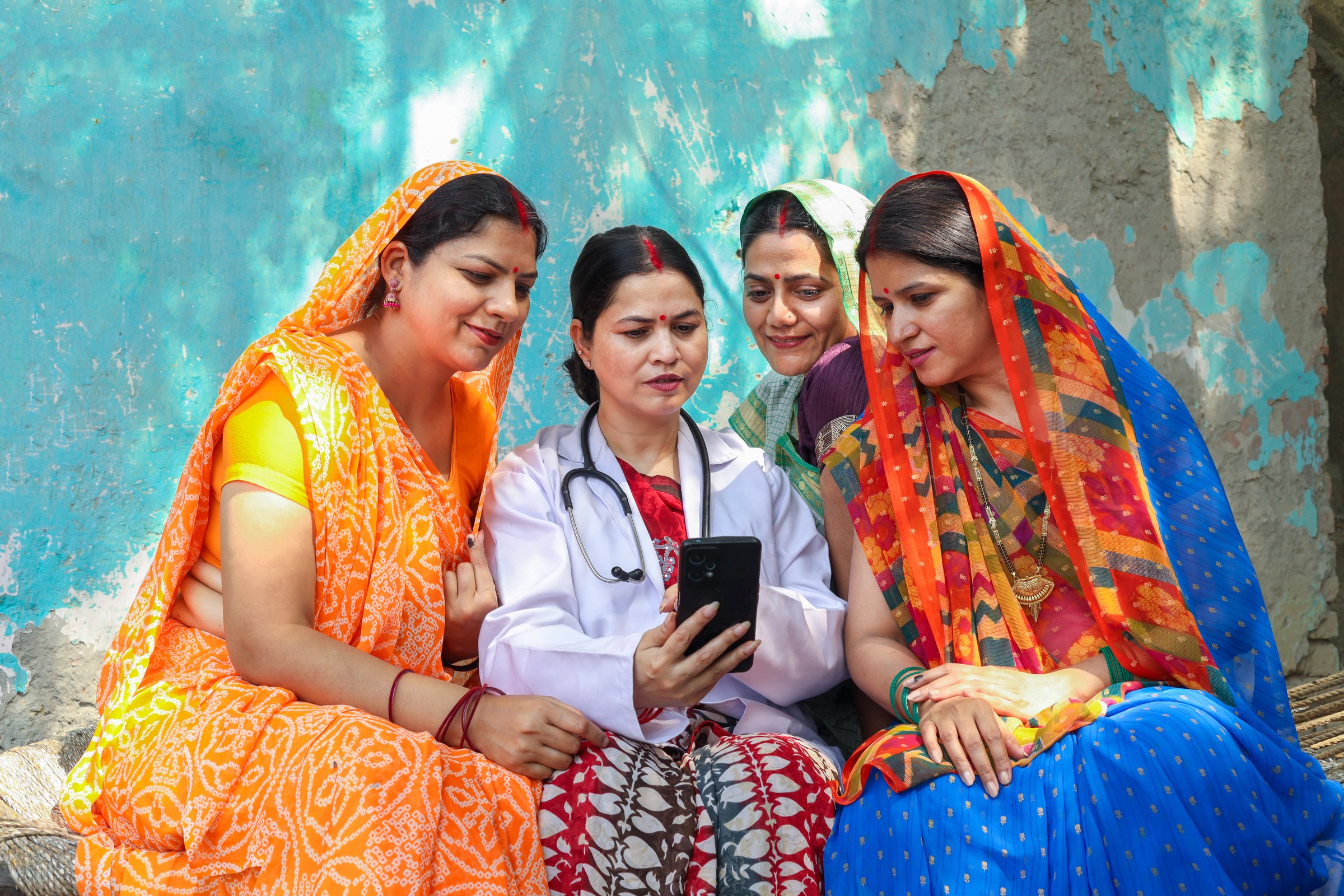 Indian female doctor showing rural indian women online government scheme or spread healthcare awareness in people of india.