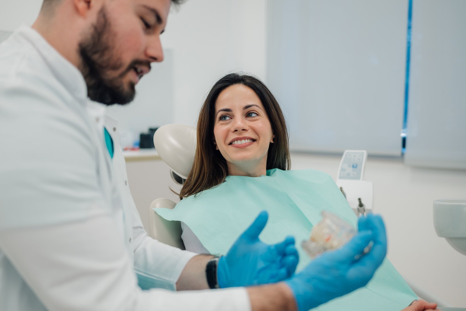 Dentist explaining to patient treatment using dentures in a dental practice