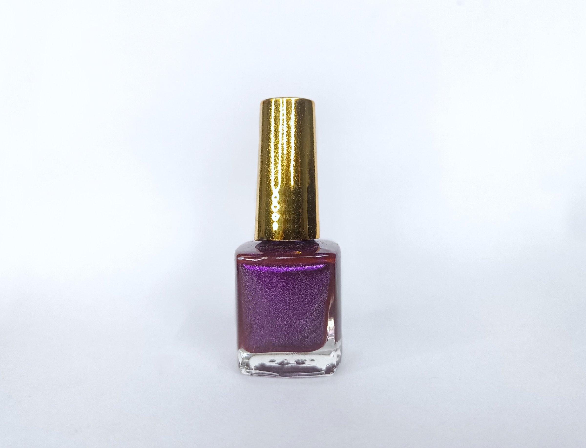 Esmalte violeta brillante con tapa dorada