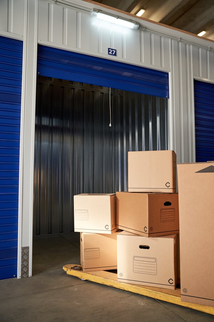 Professional movers expertly navigating furniture through a room, carefully carrying boxes to a waiting truck for delivery services.