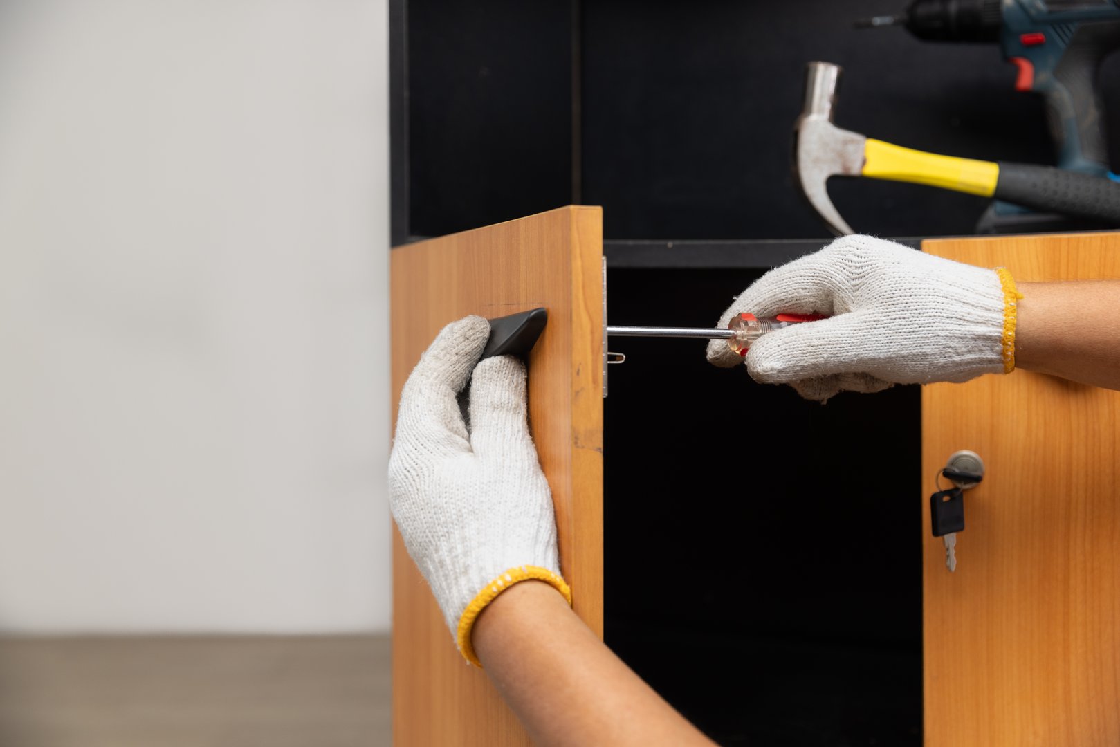 Handyman fixing cabinet door handle.