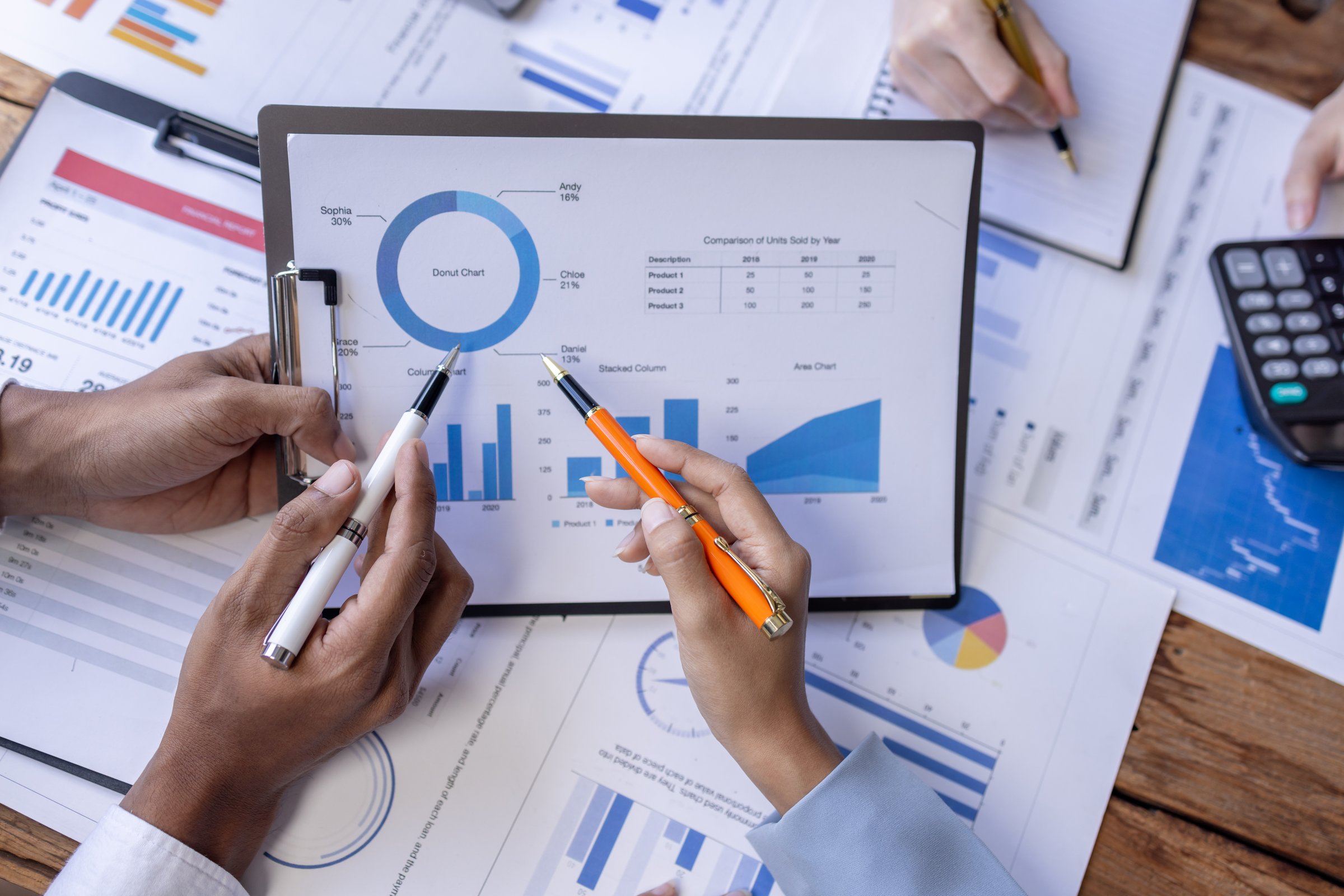 Group of confident business people point to graphs and charts to analyze market data, balance sheet, account, net profit to plan new sales strategies to increase production capacity.