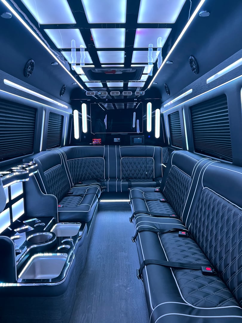 Luxurious limo interior with blue LED lighting, leather seats, and drink holders. Sleek, modern design.