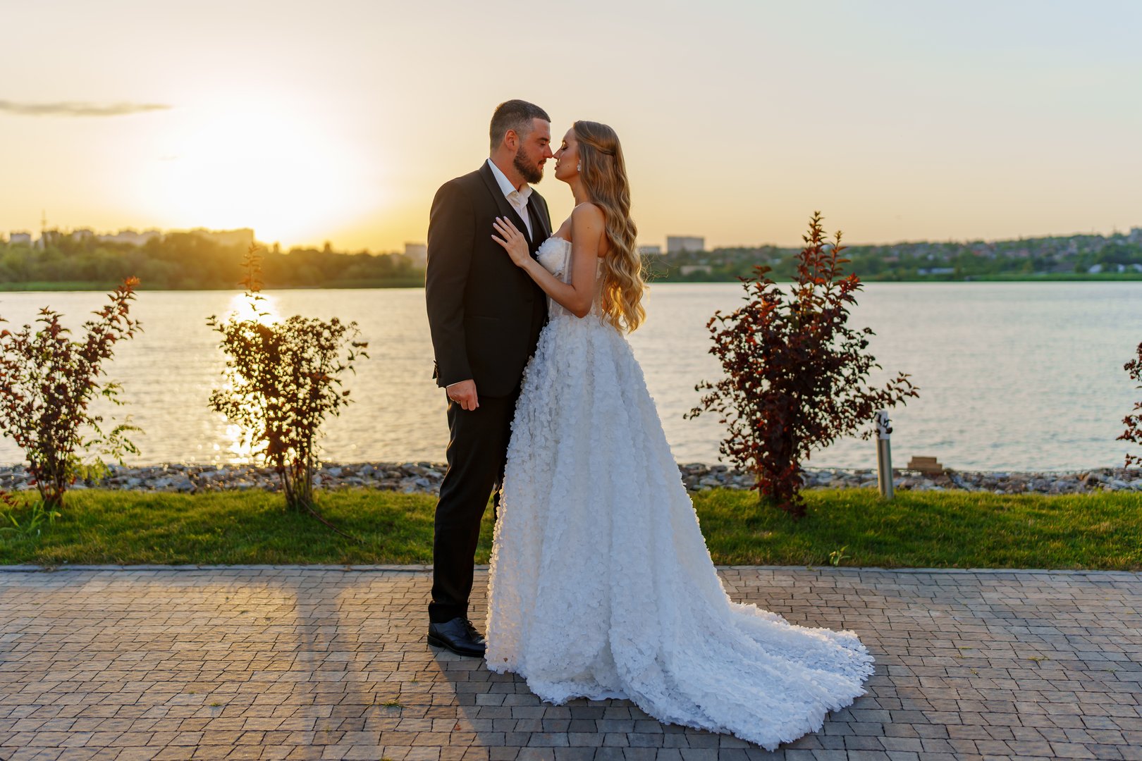 Gentle and happy bride and groom at sunset on the riverbank. Romantic photo shoot. wedding traditions. Classic fashionable clothes for newlyweds.