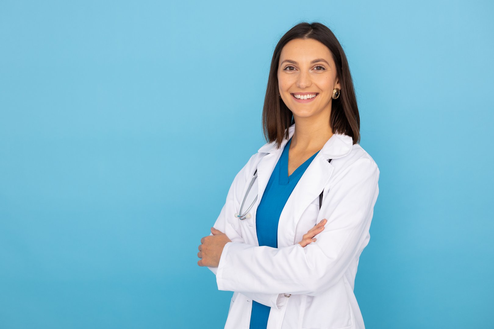 Confident medical professional crossing arms, expressing healthcare expertise with positive demeanor