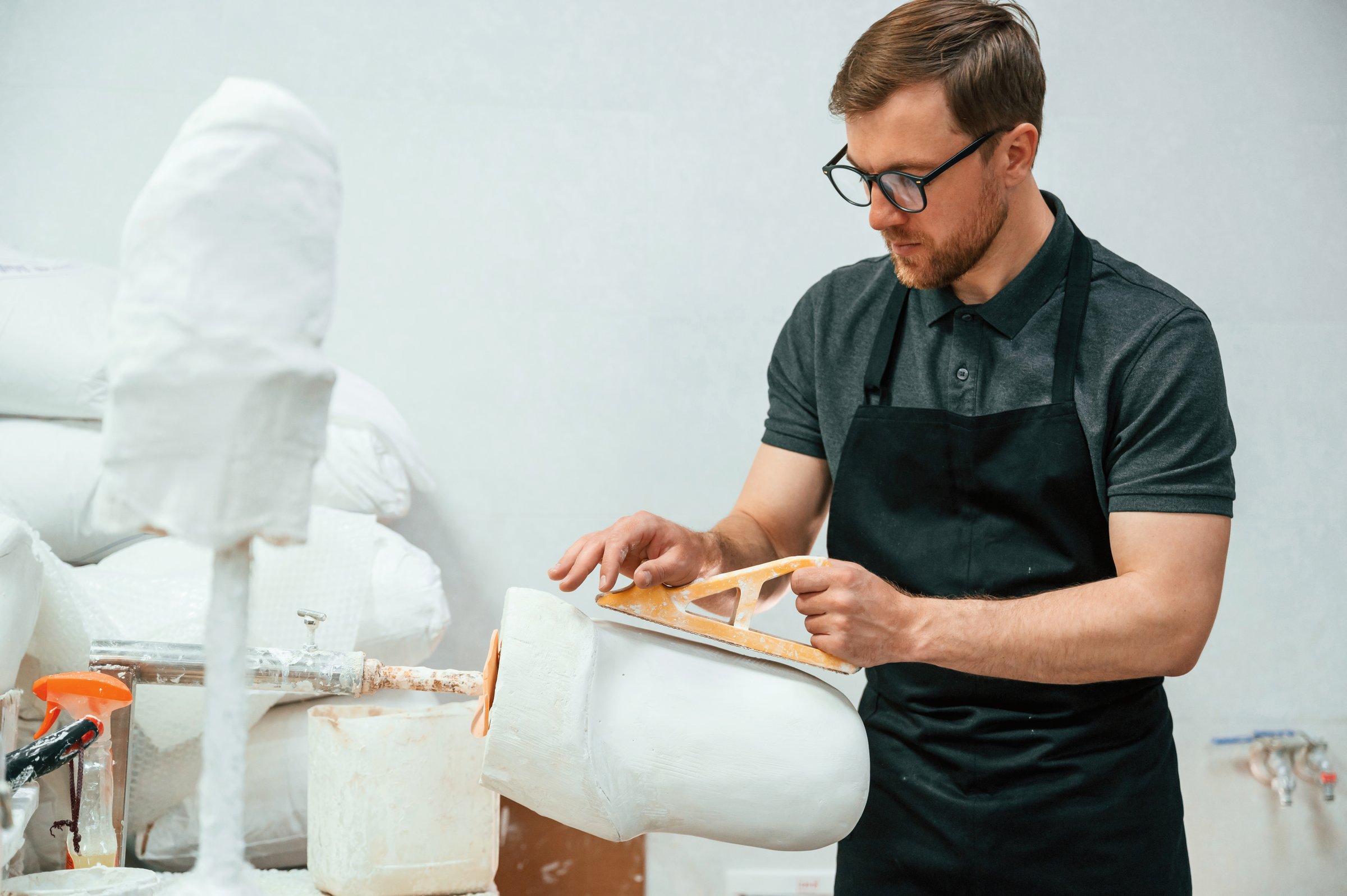 Raw product for prosthesis. Technician working in modern laboratory.