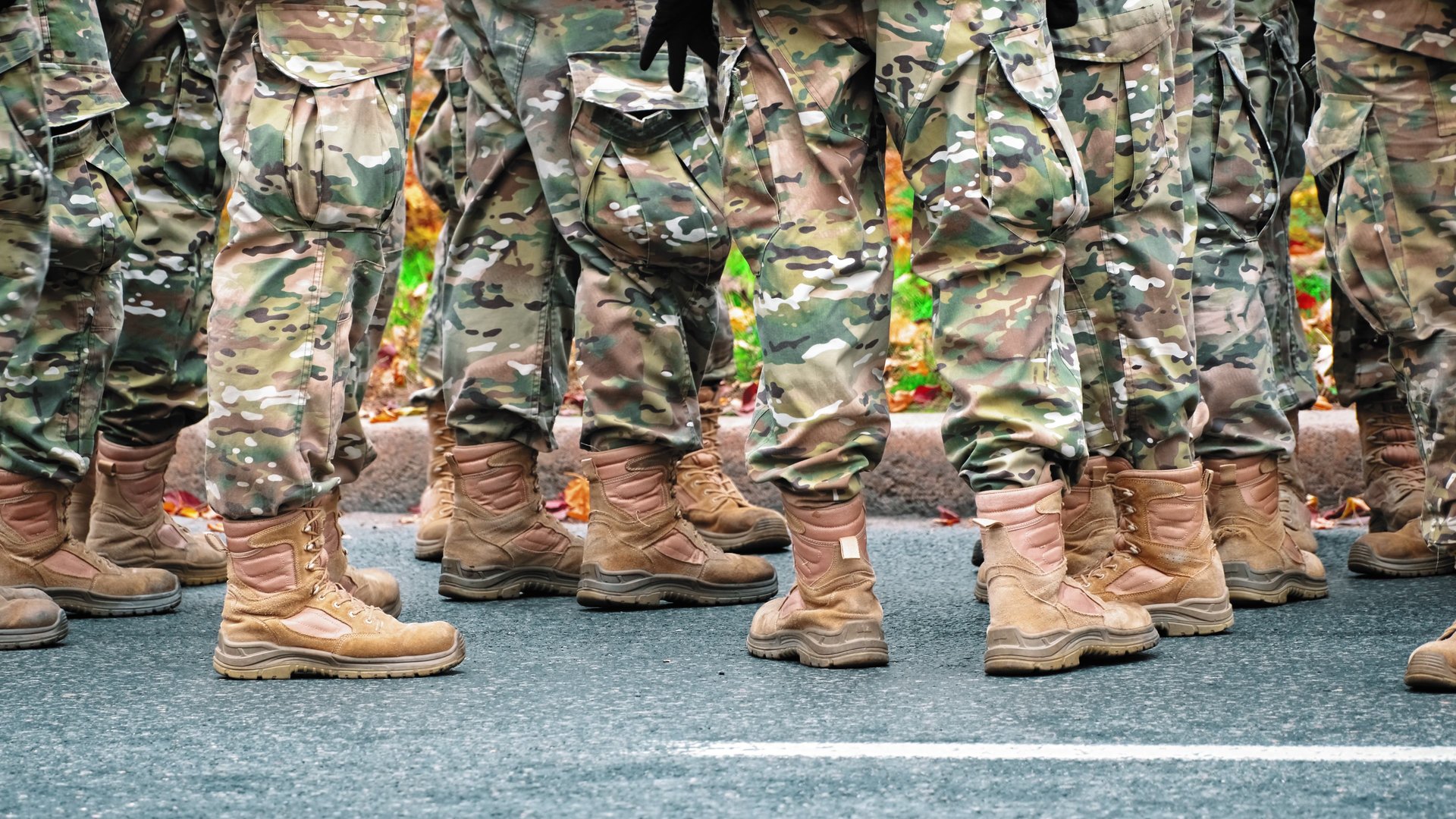 Group of Soldiers Wearing Camouflage Unifroms and Tactical Boots Standing on Asphalt Road