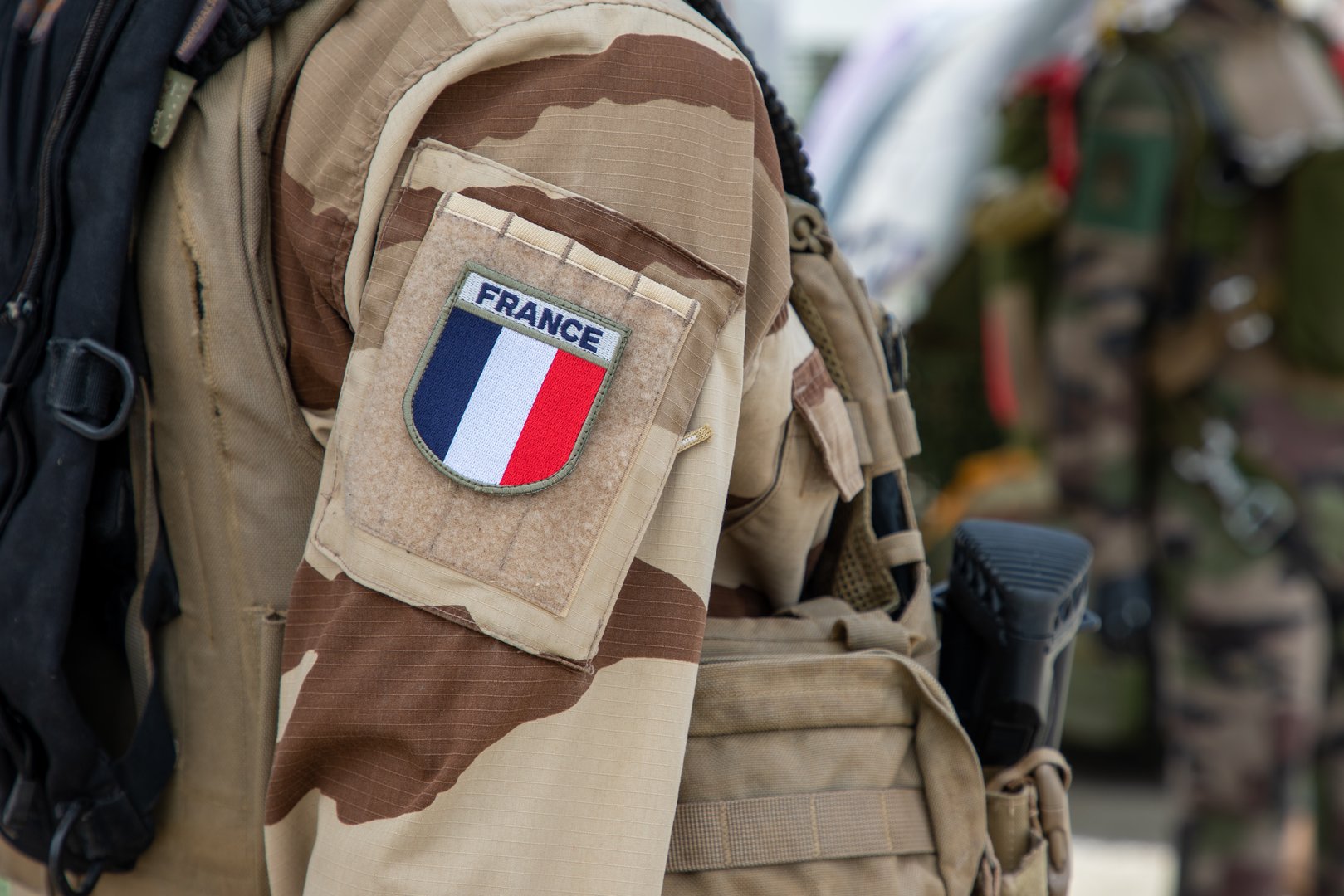 French logo text colors soldier in uniform during military parade