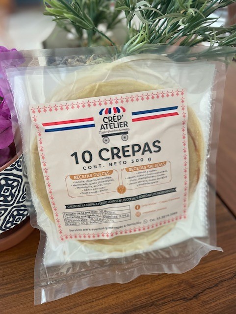 Pack of 10 crepes from Crep'Atelier on a wooden table with a floral decoration in the background.