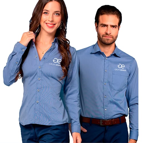 Two individuals wearing matching blue button-up shirts with company logo, posing against a white background.