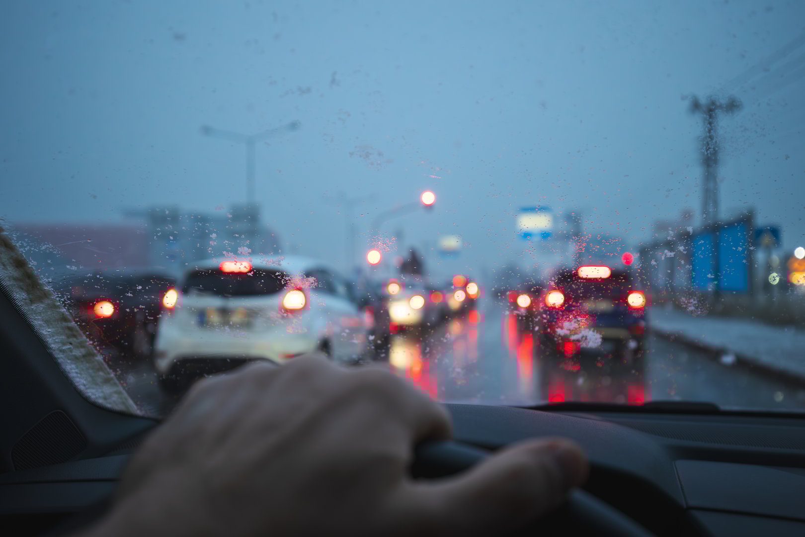 Driving car on highway on a snowy morning , close up of hands on steering wheel
