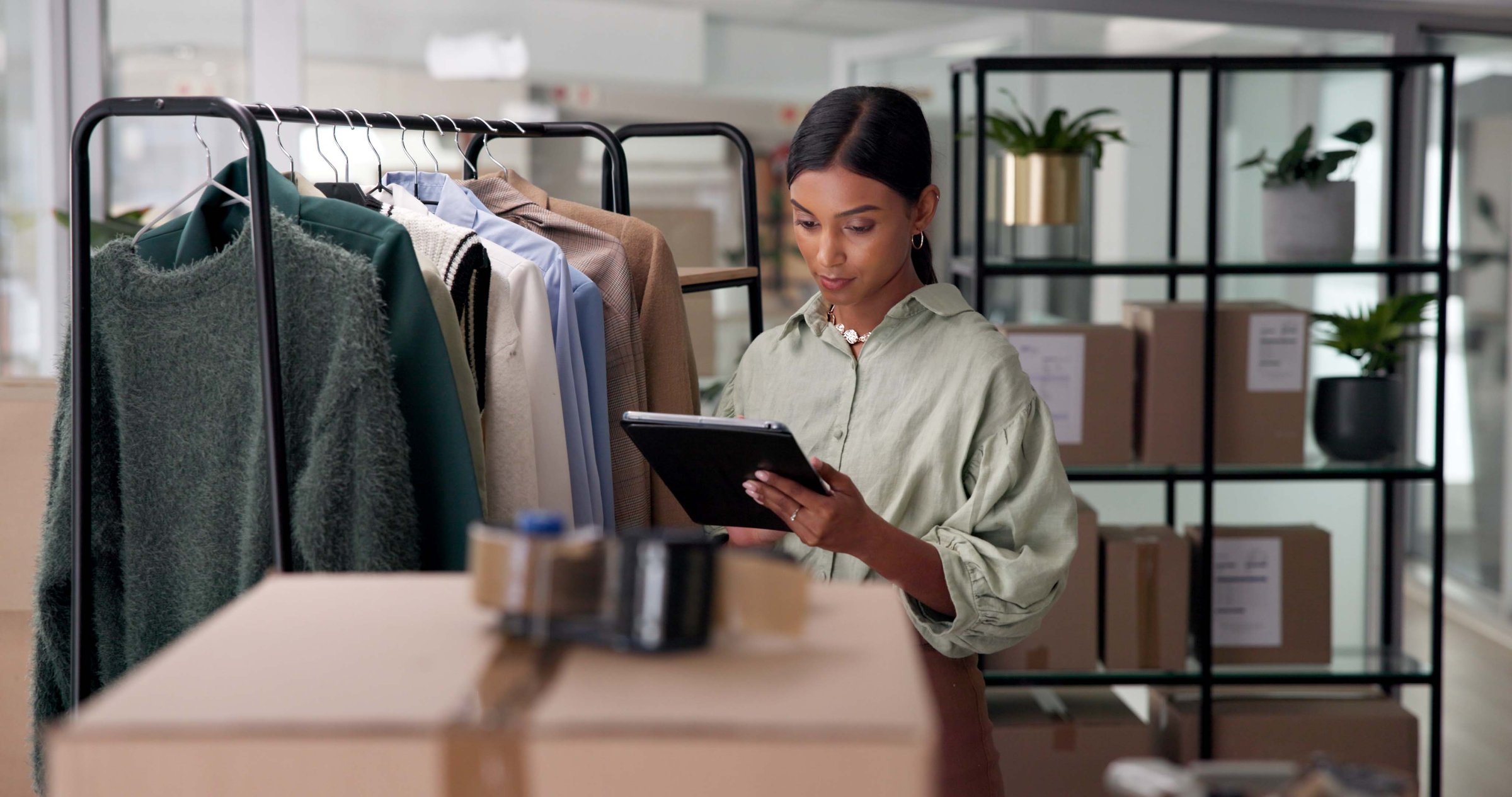 Woman, tablet and inventory check at clothing store, online and update digital stock for business. Fashion, female person and upload on retail website in workplace, storage inspection and boxes