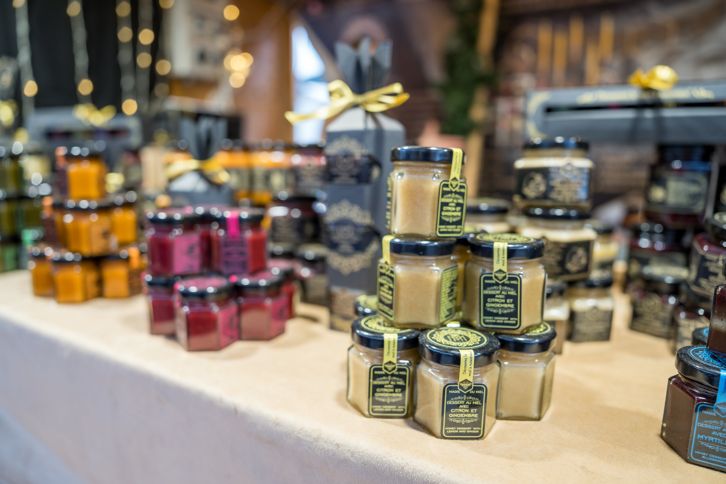 Puteaux,France-14.12.2024 Vibrant jars of homemade preserves are artfully arranged on a table at a bustling market. The warm autumn atmosphere adds charm to the lively setting.
