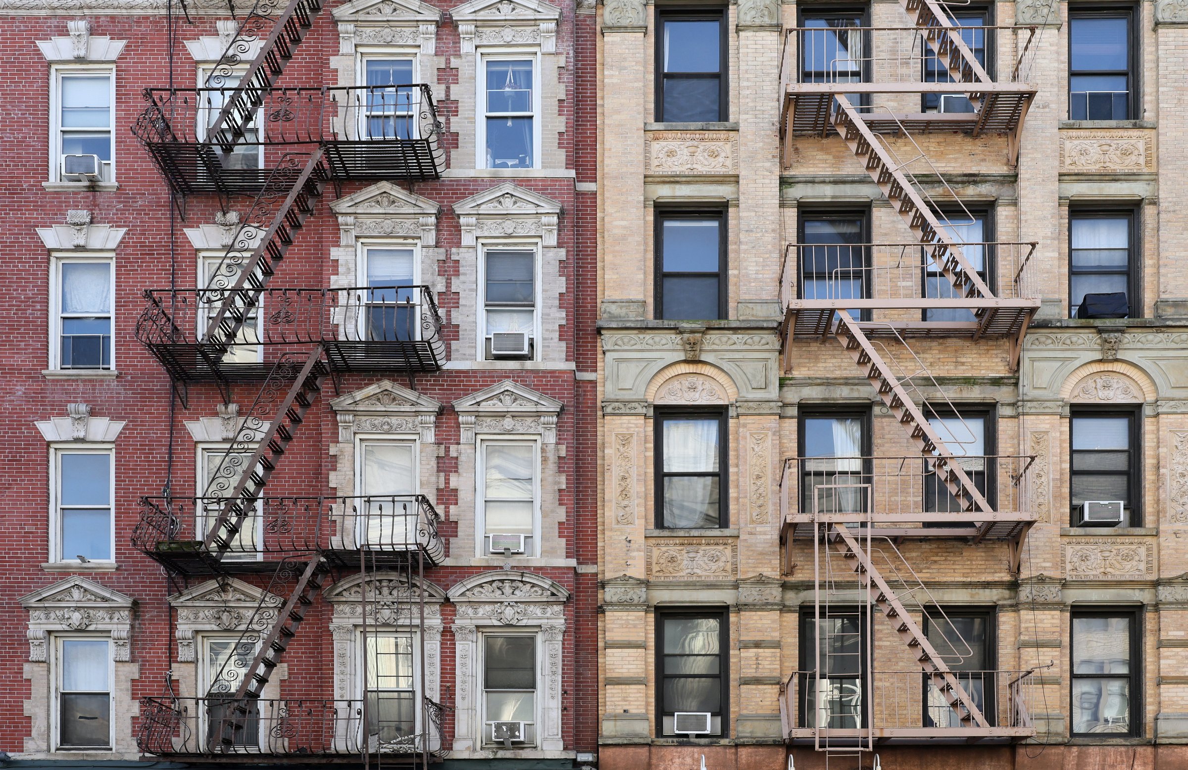 New York City, old apartment building with external fire ladder and ornamental carvings around windows