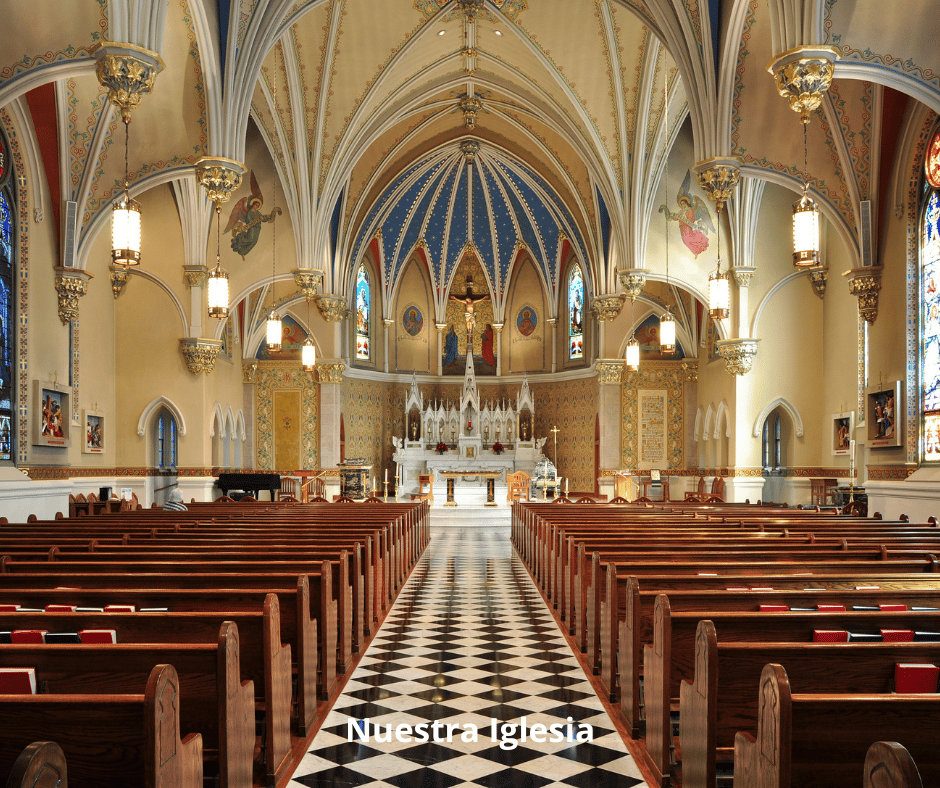 Interior of a church with ornate ceiling, stained glass windows, and wooden pews facing a detailed altar at the front.