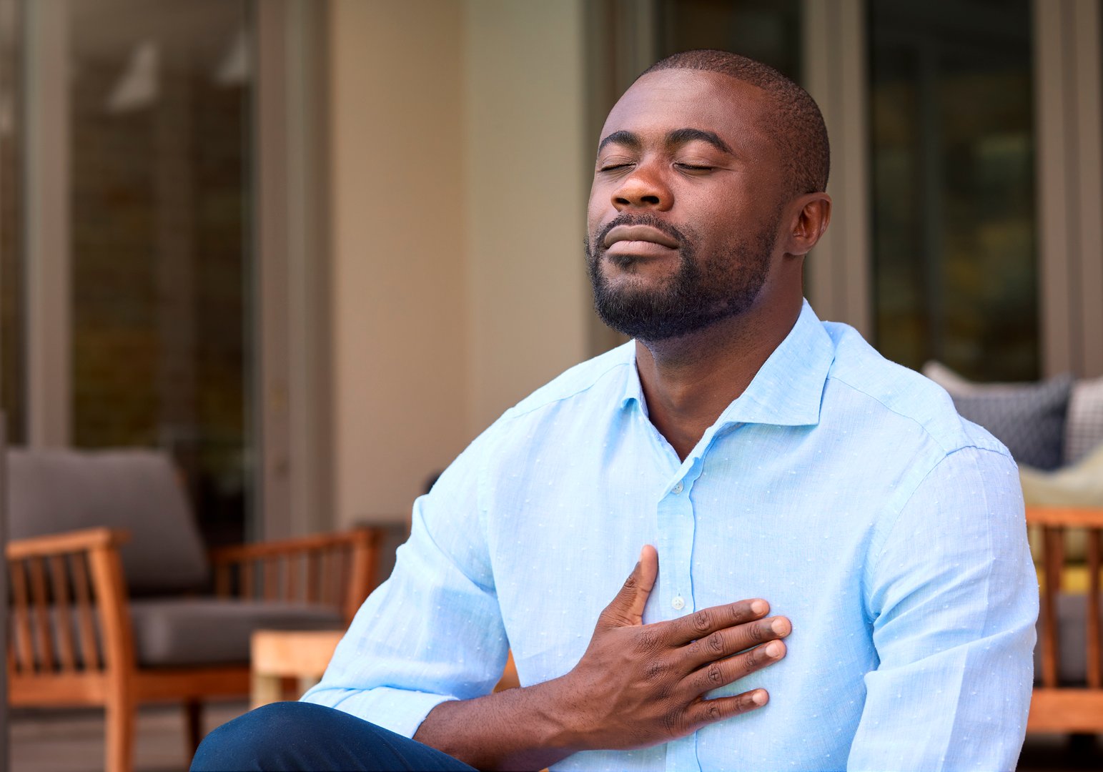 Man At Home Sitting On Deck Closing Eyes And Breathing Deeply Enjoying Peace And Calm