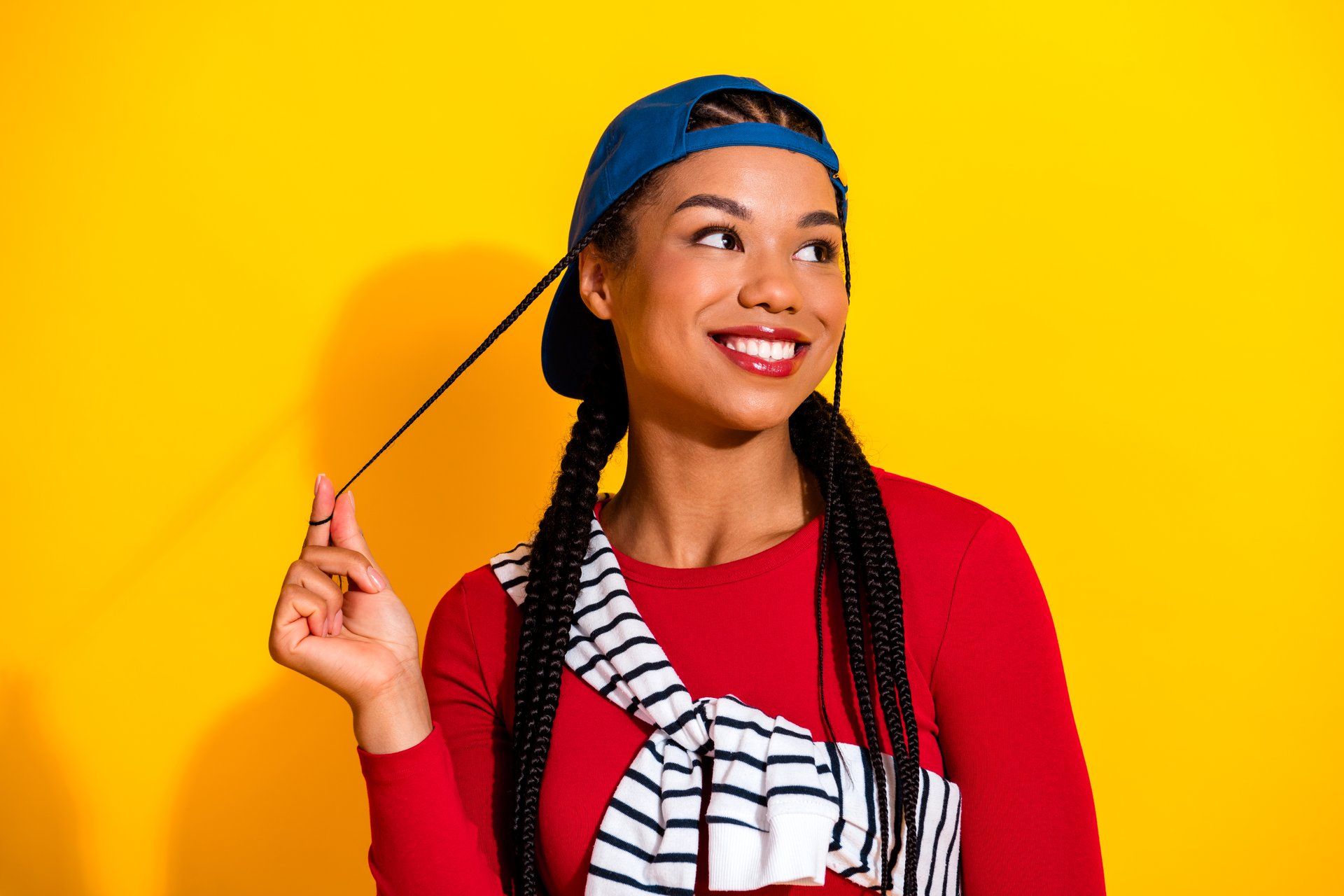 Vibrant portrait of a joyful young woman with braids wearing red top