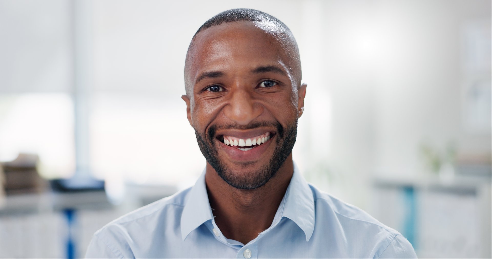 Smile, pride and face of businessman in office with positive, good and confident attitude for legal career. Happy, professional and portrait headshot of young male lawyer in modern workplace.