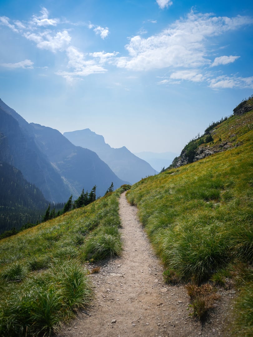 Foot path with mountain views and lush grass surrounding