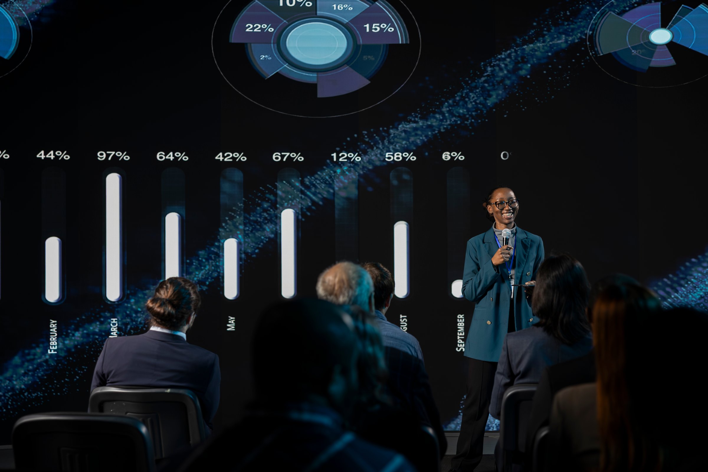 Black female speaker addressing audience at international business event