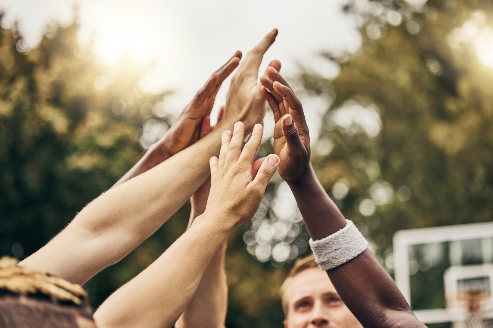 Basketball, hands and team of men high five for outdoor game. Success, diversity and victory in sports for boys goal. Teamwork, diversity and support, friends on basketball court together with coach.