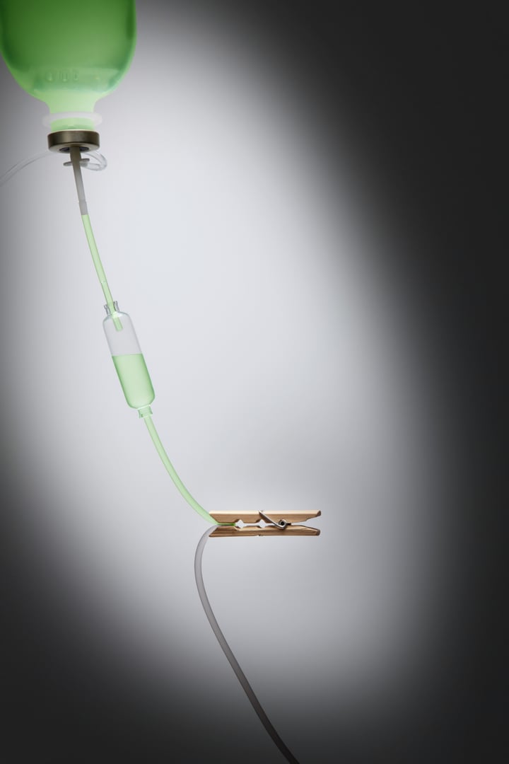 Intravenous drip with wooden peg clipping on its tube