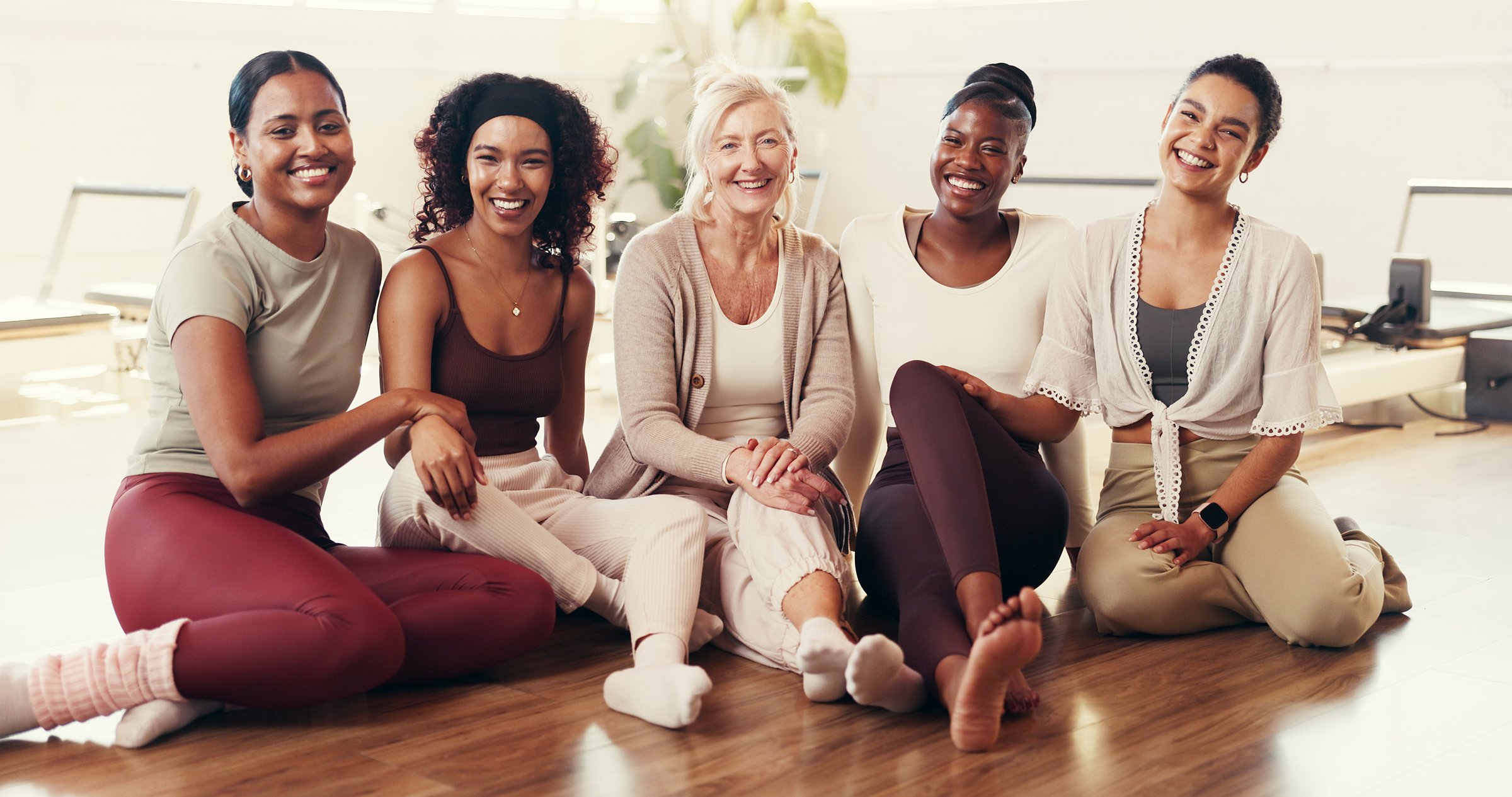 Happy, group and portrait of women in yoga class for exercise, pilates workout and wellness. Friends, trainer and people on floor together at fitness club for health, mobility and wellbeing in studio