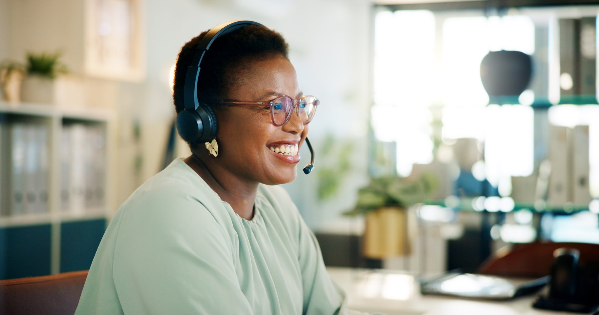 Laughing, agent or black woman in call center for consulting, questions or loan advice. Smile, sales advisor or happy African virtual assistant talking for telemarketing or communication in Nigeria