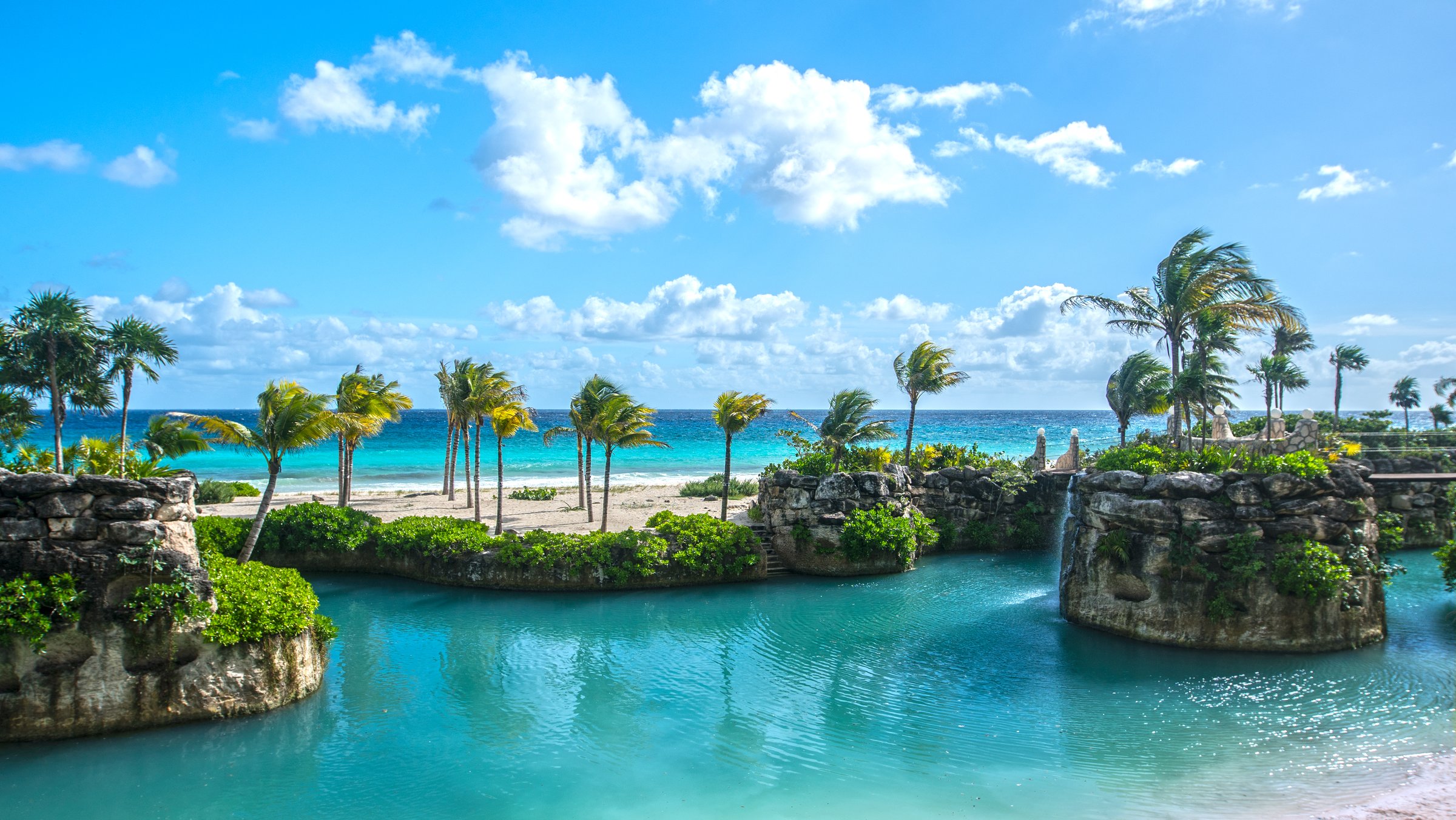 Beautiful tropical resort view with stunning turquoise waters and palm trees at Hotel Xcaret