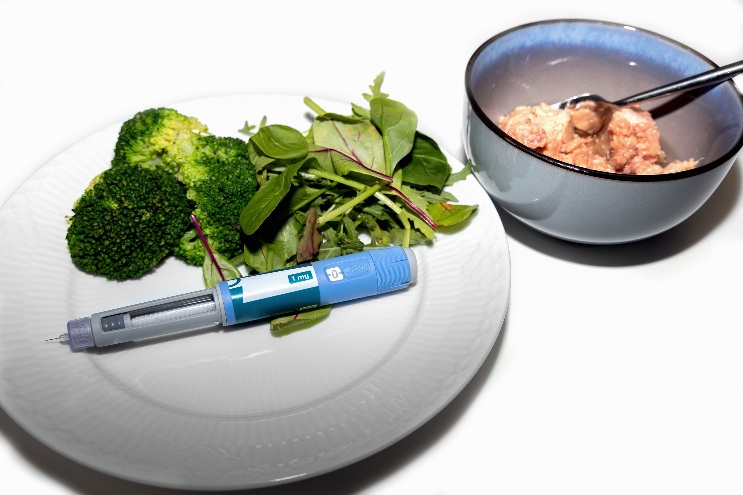 Healthy salad with tuna and Ozempic pen for diet concept