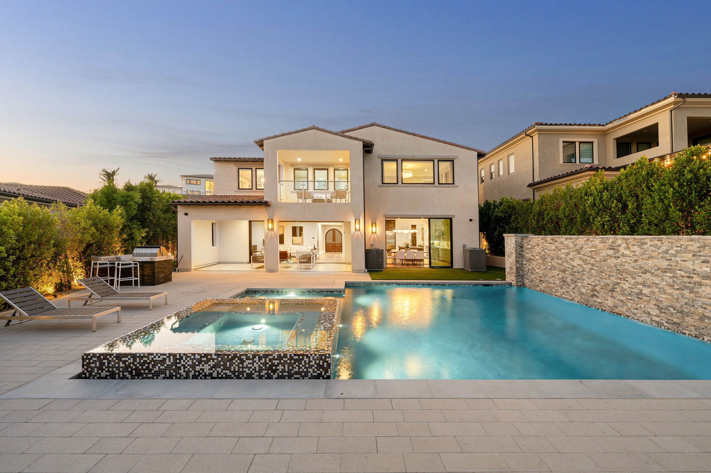 Luxurious modern house with a swimming pool and outdoor lounge area at dusk, showcasing contemporary architecture and serene ambiance.
