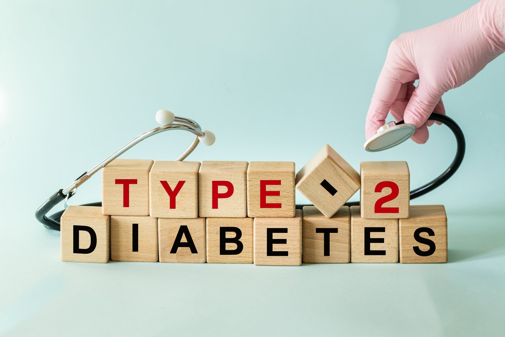 Type 2 diabetes. Diagnostic and health concept. Oral glucose tolerance test (OGTT) to detect glucose tolerance abnormalities or diabetes in a patient. Written on wooden blocks, hand with stethoscope