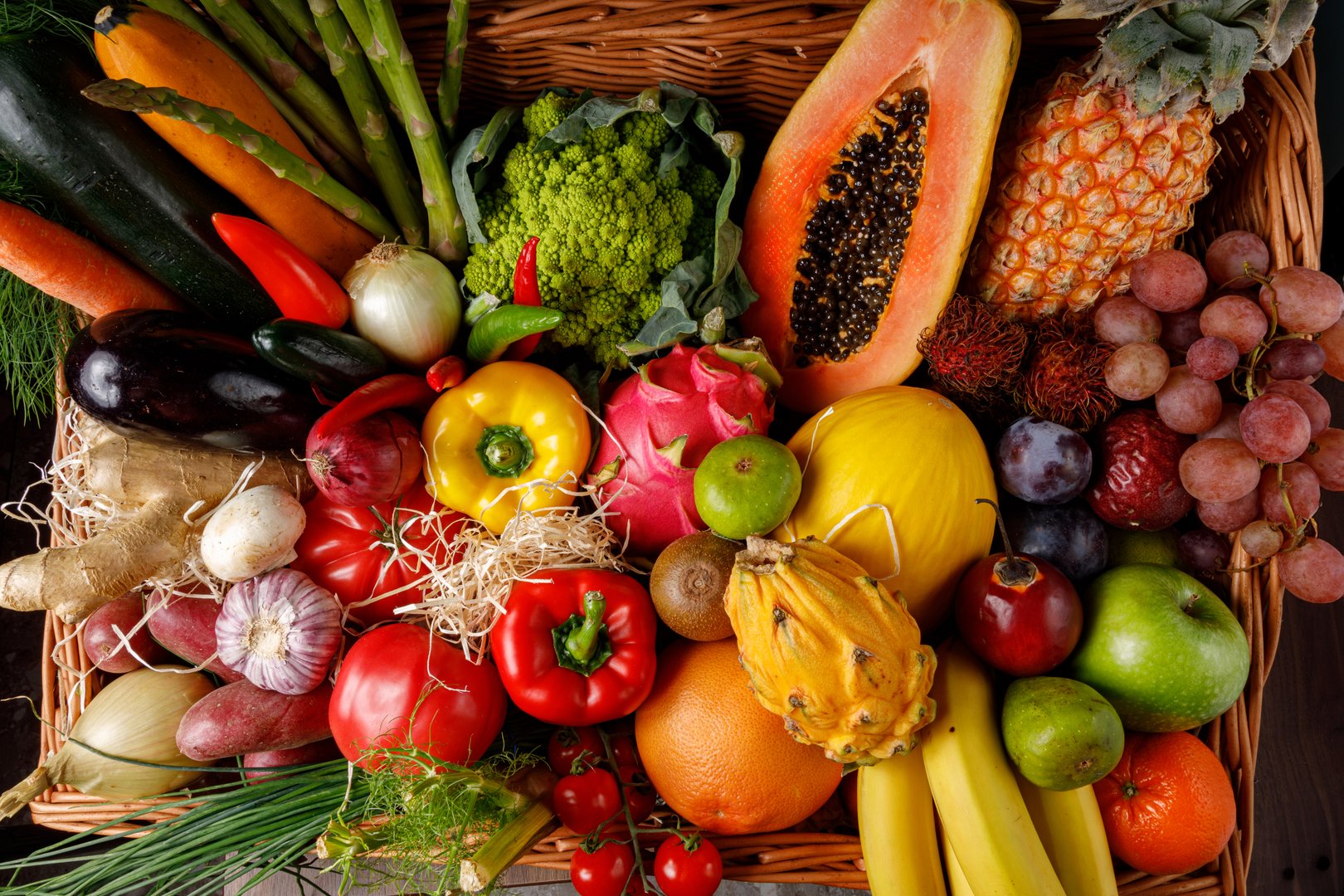 A vibrant and colorful array of seasonal produce featuring various fruits and vegetables placed in a rustic basket