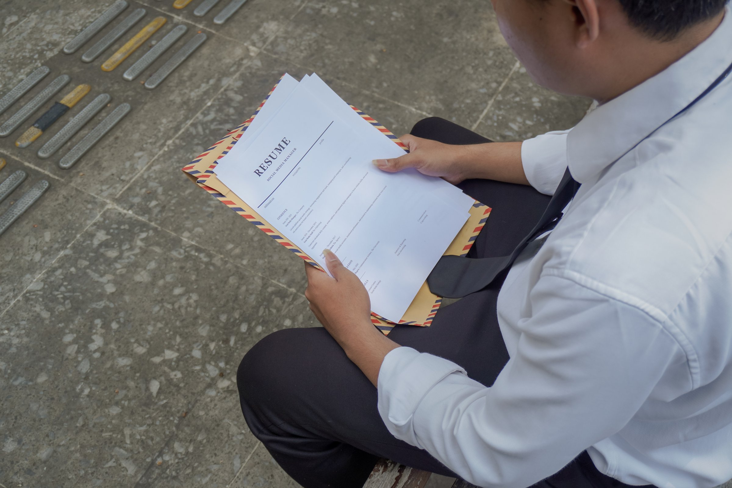 Close up of Asian job seeker holding his resume document for work application